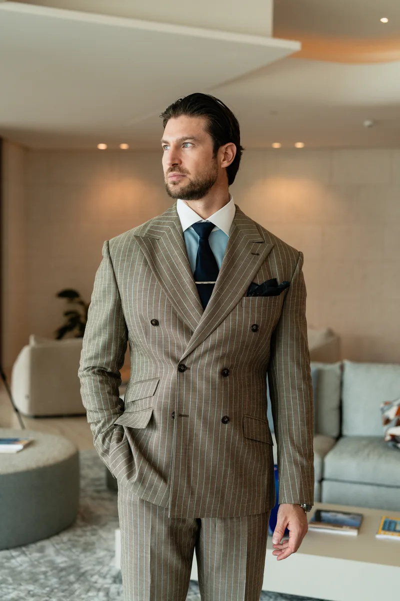 Taupe double-breasted pinstripe bespoke suit styled in a contemporary Dubai home
