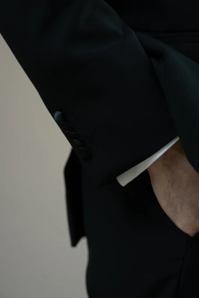 Close-up of a bespoke tuxedo sleeve with covered buttons and a white dress shirt cuff