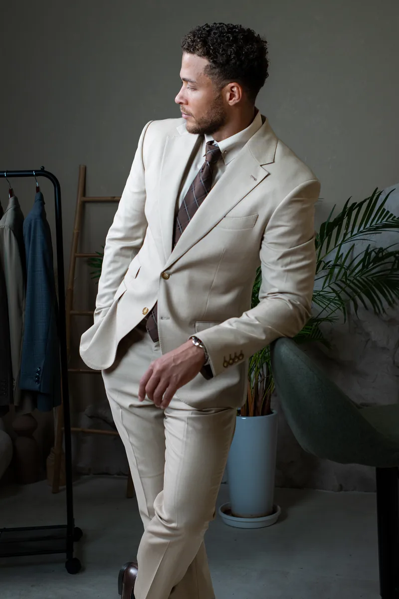 Cream tailored wedding suit with a patterned tie, suited to an outdoor wedding in Dubai